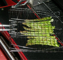 Asparagus grilling in a fish BBQ cage